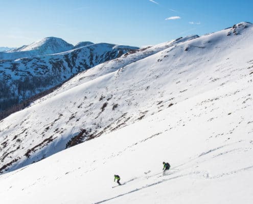 Skitourengeher bei der Abfahrt Richtung Hundsfeldhütte mit Blick auf die Nockberge